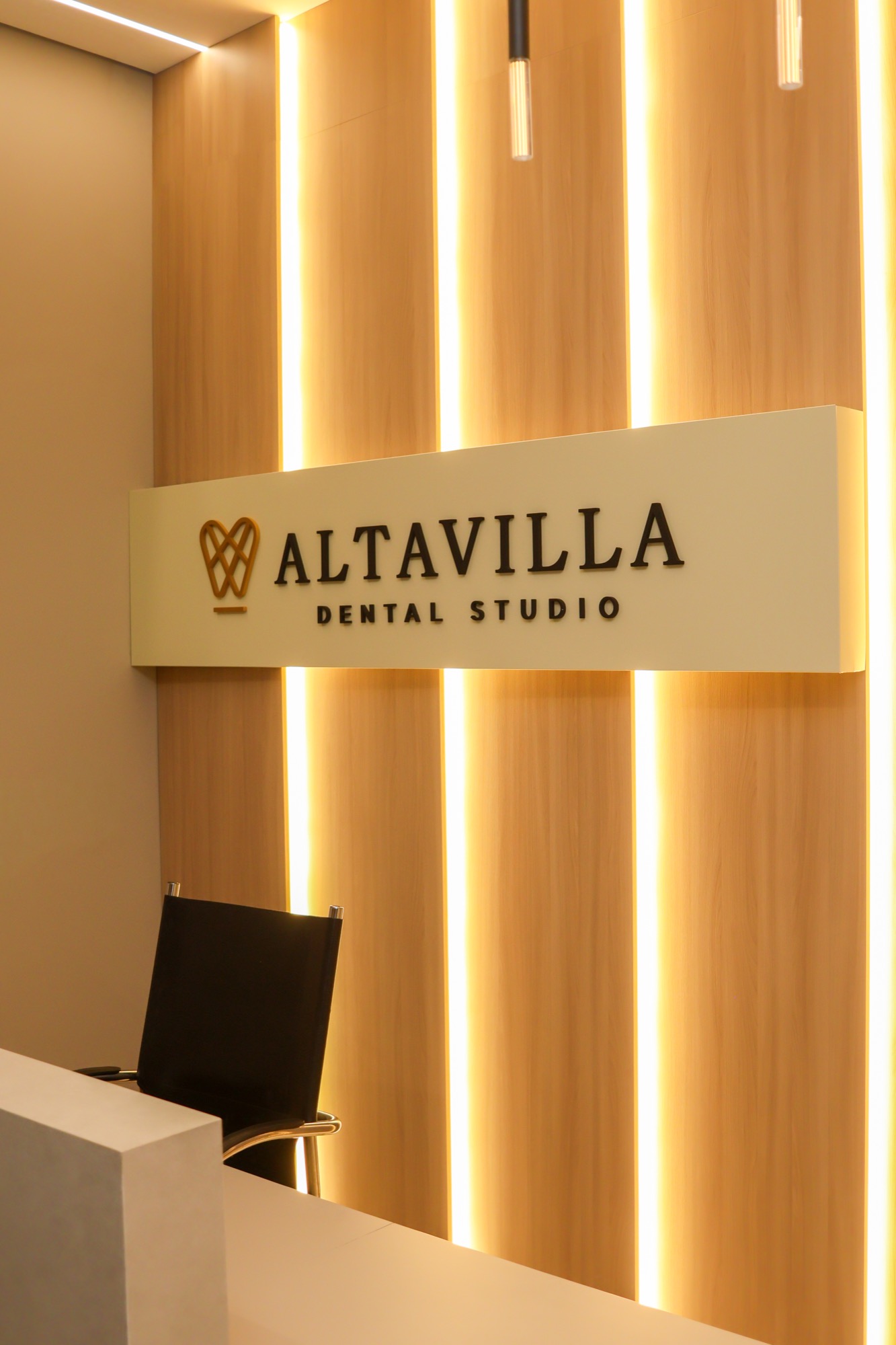 Recepção real da Altavilla, com marca da clínica e iluminação acolhedora.